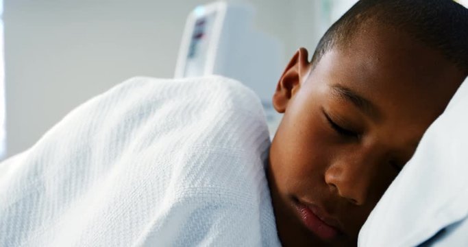 Close-up of sick boy sleeping on the bed in the hospital