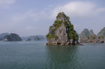 Obraz premium Beautiful limestone mountain scenery at Ha Long Bay, North Vietnam. Cloudy winter weather