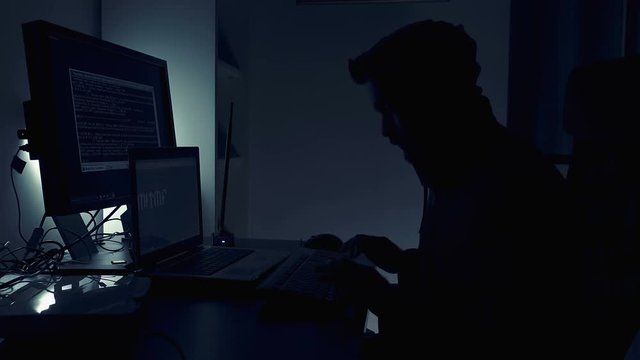  Hacker working at computer into the night