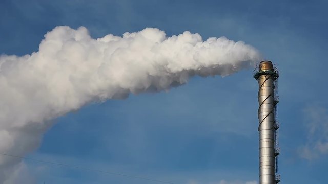 Pipe throws grey smoke in blue sky. Air Pollution Concept