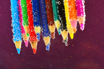 colored pencils in sparkling water