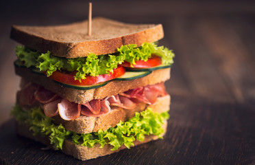 Delicious sandwich with  ham, cheese, bacon and lettuce