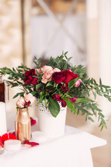 beautiful bouquet from red roses on a table in a vase. Flower Scenery of a wedding table