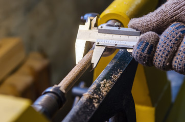 Carpenter measures the diameter of the parts