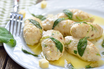 Deftige Südtiroler Kasnocken mit gebräunter Butter und Salbei auf weißem Teller  serviert -...