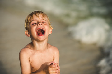 Young boy laughing on sunny day 