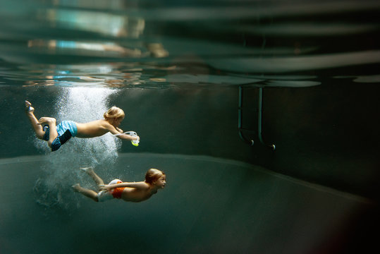 Two boys diving in pool 