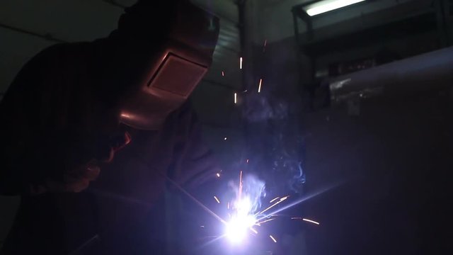 Industrial worker welding with spark