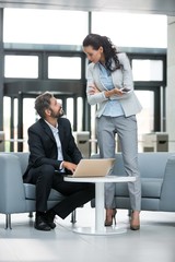 Businessman having a discussion with colleague over laptop