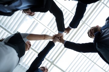 Group of happy businesspeople giving high five to each other