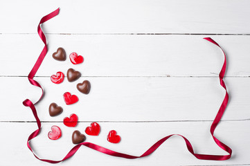Chocolate candies and red lollipops with red satin ribbon.The form of hearts. Love concept. Valentine day.