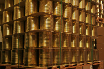 Stapel von goldenen Dosen in der Fabrik auf Europaletten