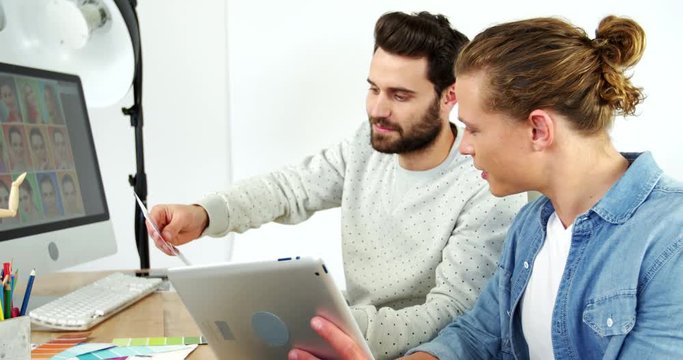 Two graphic designer using digital tablet while discussing over graphics in office 4k