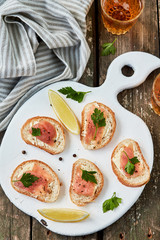 Smoked salmon and cream cheese sandwich on a chopping board. Top view