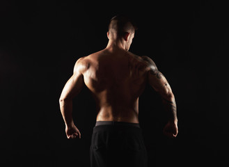Fototapeta na wymiar Unrecognizable man shows strong back muscles closeup
