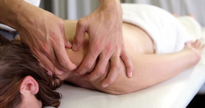 Physiotherapist giving back massage to a woman in clinic 4k