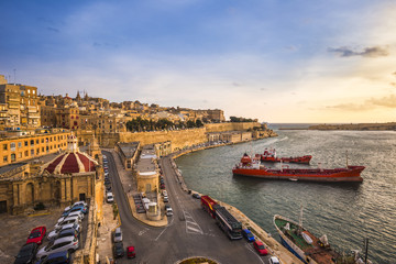 Fototapeta na wymiar Valletta, Malta - Sunrise at the Grand Harbor of Valletta, the capital city of Malta with blue sky and ships 