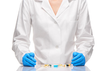 Tablets and capsules in front of doctor in white gown