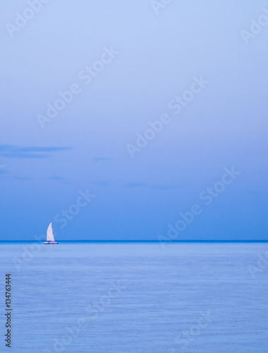 Lonely Yacht On Horizon Sailing Boat Between The Sky And