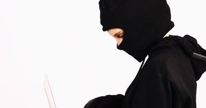 Female burglar doing online shopping with laptop and credit card on white background 4k