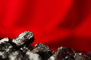 Raw coal nuggets on red soft  background