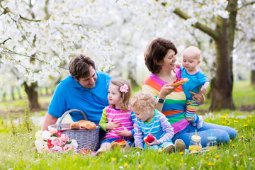 Family with children enjoying picnic in spring park