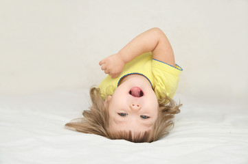 Little girl having fun lying on back spine, back bend, bridge figure, happy smiling child,...