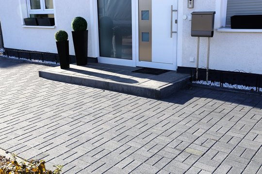 Modern gepflasterter Eingangsbereich an Wohnhaus