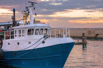 Naklejka premium Large Blue Fishing Boat Docked at Sunset - Jaffa Port - near Tel Aviv, Israel
