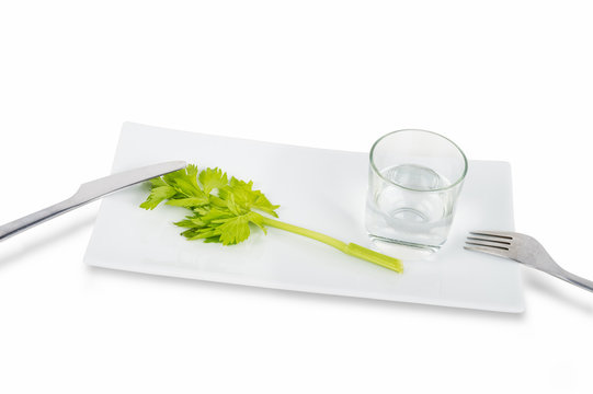 Stem of celery and glass of water isolated on white background.