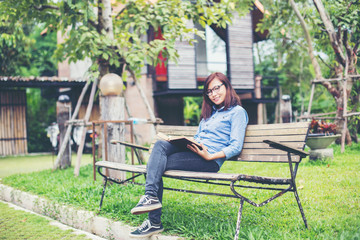 Fototapeta premium Hipster charming girl relaxing in the park while read book, Enjo