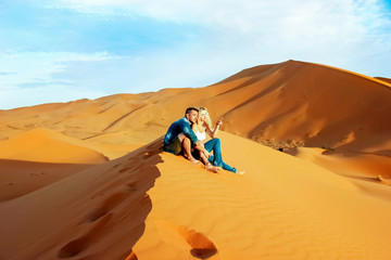 Loving couple in the Sahara Desert. Morocco. - obrazy, fototapety, plakaty