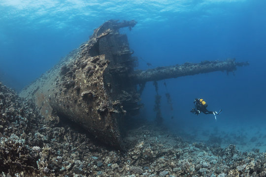 Scuba diver swimming near shipwreck