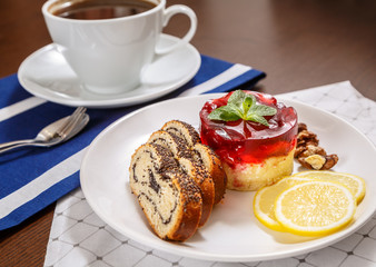 Маковый рулет, творожный торт, лимоны и орех на тарелке
