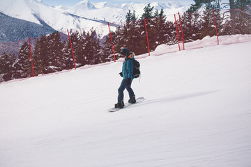 Woman snowboarder on the slopes of the resort on a winter day.