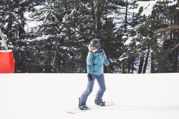Woman snowboarder on the slopes of the resort on a winter day.