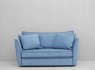 Modern couch on light wall background
