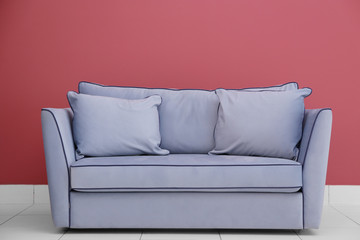 Modern couch on red wall background