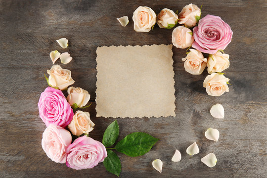 Floral frame with card on wooden background