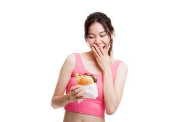 Beautiful Asian healthy girl enjoy eating  hamburger.