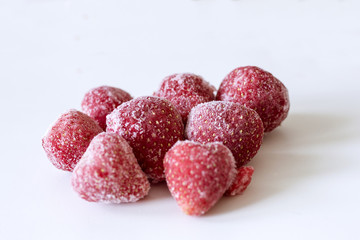 Frozen strawberries on white background. Close up