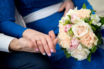 Obraz na płótnie Canvas Lovers hold hands and wedding bouquet