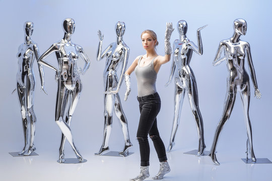 attractive woman on background of many  metallic shiny mannequin