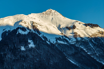 Snowy Mountain tops in the blue sky sun