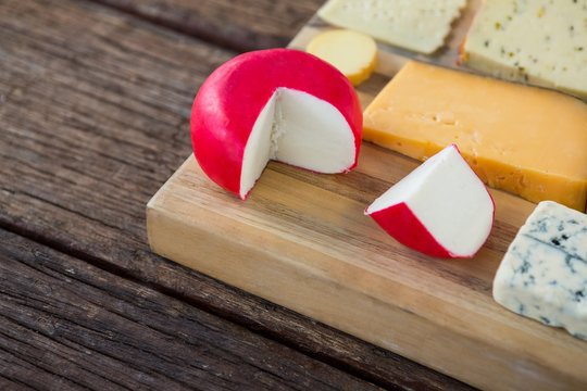 Variety of cheese on wooden board