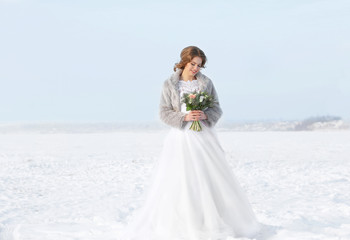 Fototapeta na wymiar Beautiful bride with bouquet outdoors on winter day
