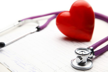 Heart with a stethoscope, isolated on wooden background