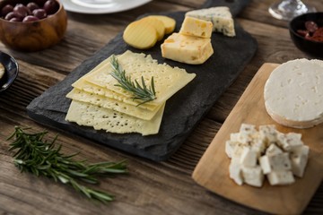 Cheese, olives, biscuits and rosemary herbs on wooden