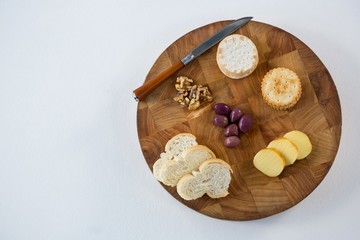 Bread, crackers, olives, walnut and knife