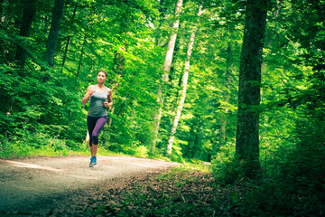 Obraz na płótnie Canvas Young Woman Jogging In The Forest